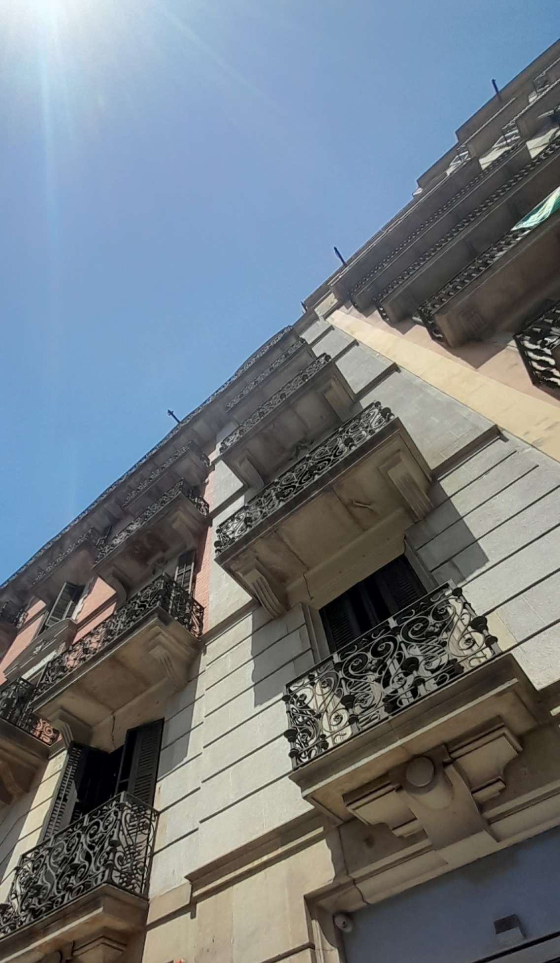 a very low shot of a dozen or more balconies with intense wrought scroll balustrades and layers and layers of corbels and mouldings and layers of other layers