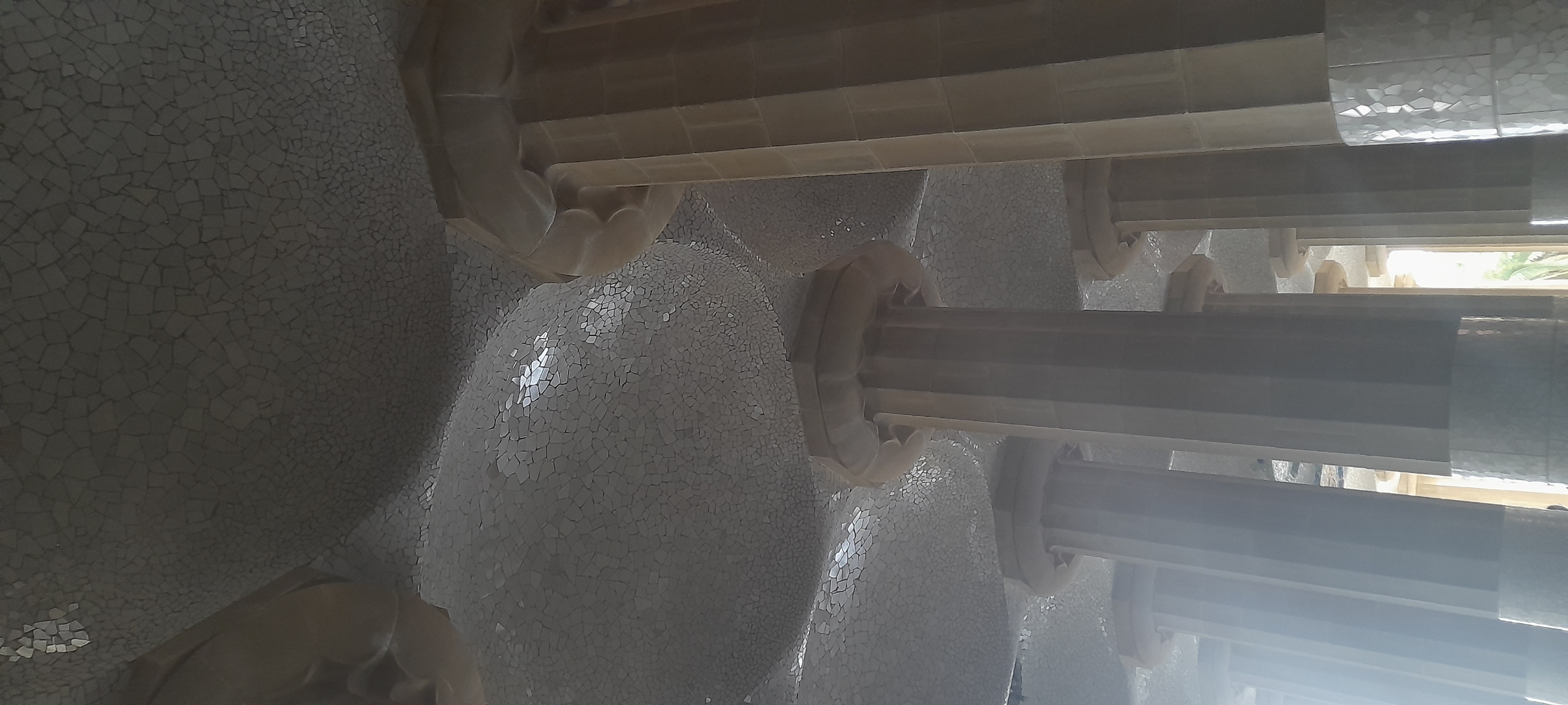 some very grand scalloped columns, holding up the lookout plaza above; the ceiling between each column is a dome full of tile. The base of each column is also tiled from floor to about shoulder height, I assume for the ease of washing off urine.